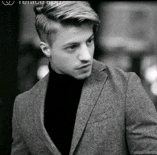 a black and white photo of a man wearing a suit and a turtleneck