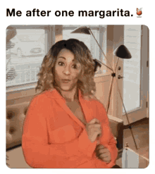 a woman in an orange shirt is sitting on a couch in a living room with the caption me after one margarita .