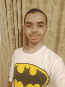 a young man wearing a batman t-shirt takes a selfie