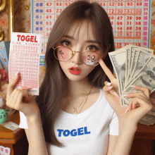 a girl wearing glasses and a t-shirt with the word togel on it