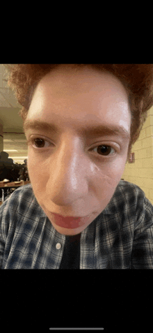 a close up of a person 's face with a brick wall in the background