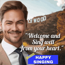 a man in a suit and tie stands in front of a sign that says " welcome and sing well from your heart "