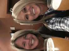 two women are smiling and holding glasses of beer in front of their faces