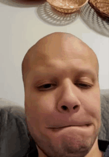 a man with a bald head is making a funny face .