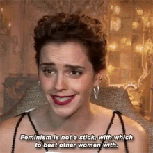 a woman is smiling and says feminism is not a stick with which to beat other women with .