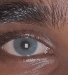 a close up of a person 's eye with a blue pupil