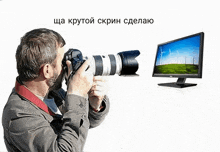 a man is taking a picture of a computer screen with russian writing on the bottom