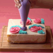 a cake is being decorated with pink and blue frosting by mr. cakes