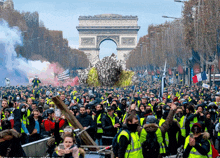 a crowd of people are gathered in front of the triumphal arch in paris