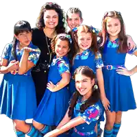 a group of girls in blue uniforms are posing for a picture with their teacher