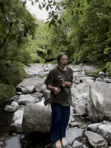 a person standing on a rock in a stream with a shirt that says columbia on it