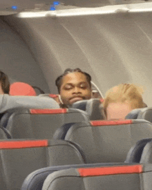 a man sitting on a plane with his head resting on the arm rest