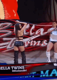 a woman is standing in front of a banner that says bella twins on it