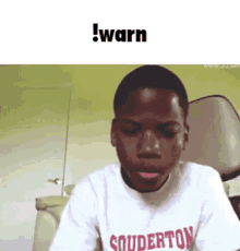 a young boy wearing a white t-shirt with the word souderton on it .