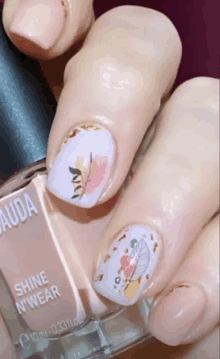 a close up of a woman 's nails and a bottle of shine n' wear nail polish