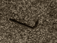 a small wrench is laying on a carpeted surface