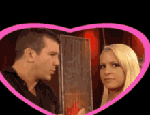 a man and a woman are looking at each other in a pink heart shaped frame