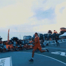 a man in orange shorts is running on a basketball court in front of a sign that says " magic "