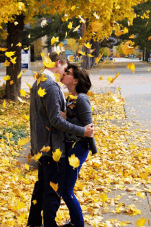 a man and a woman kissing in front of a sign that says ' a ' on it