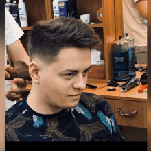 a man is getting his hair cut in a barber shop with a bottle of fabricide on the counter