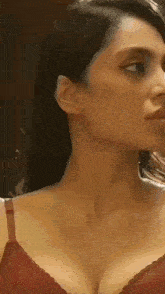 a woman is wearing a red bra and looking at the camera .