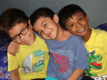 three young boys are posing for a picture with one wearing a cool beach t-shirt