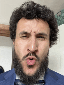 a man with a beard is making a funny face with his mouth open