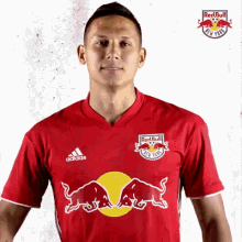 a man is wearing a red shirt that says red bull new york