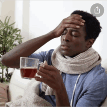 a man with a scarf around his neck is holding a cup of coffee