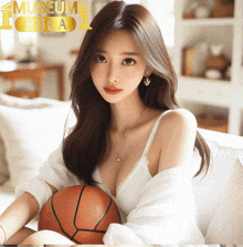 a woman sitting on a couch holding a basketball with a museum bola logo behind her