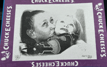 a drawing of a woman kissing a child is on a chuck e cheese 's box