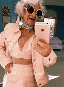 an elderly woman is taking a picture of herself with her iphone