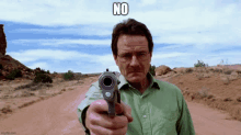 a man in a green shirt is pointing a gun at the camera with the caption " no " above him