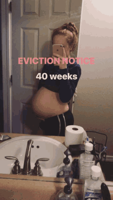 a pregnant woman is taking a selfie in front of a mirror with the words " eviction notice 40 weeks "