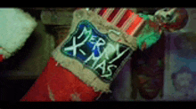 a christmas stocking that says merry xmas is hanging on a wall .