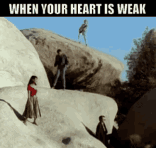 a group of people standing on top of a rock with the words " when your heart is weak " below them