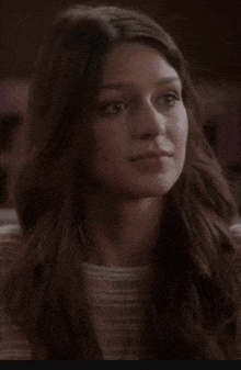 a close up of a woman 's face with long brown hair .