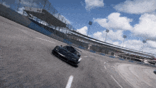 a black race car is driving down a track