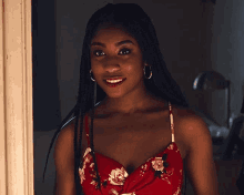 a woman wearing a red dress and hoop earrings smiles