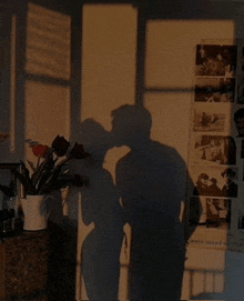 a shadow of a couple kissing on a wall