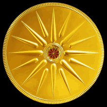 a golden coin with a red flower in the center