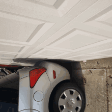 a silver car is parked underneath a garage door