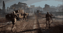 a group of soldiers are walking down a dirt road in front of a tank that says u.s. army on it