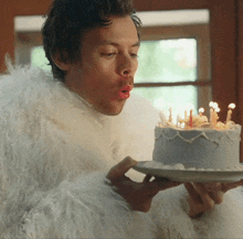 a man blowing out candles on a cake