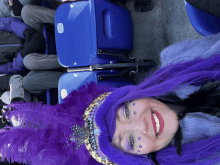 a woman wearing purple feathers and a hat that says carnaval