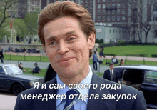 a man in a suit and tie is smiling in front of a foreign language caption