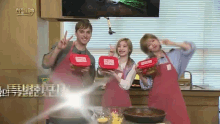 a man and two women in aprons are holding red containers with a label that says ' twice ' on it