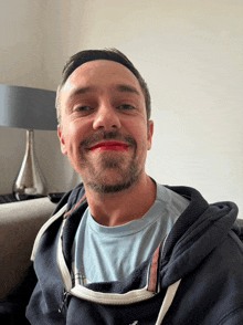 a man with red lipstick on his face wears a blue shirt