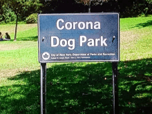 a sign that says corona dog park in front of a grassy field