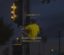 a man in a yellow shirt is sitting on a traffic light with the name everette marvin written above him